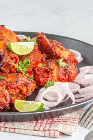 Indian Style Roasted Tandoori Chicken with Lemon, Onion, Close Up Photo. Popular Indian Chicken Appetizer.