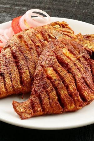 Shallow fry sea food with spices and herbs, served in a plate.